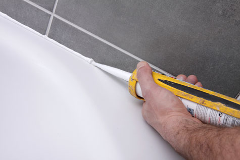 Pose de joint de silicone dans une salle de bain